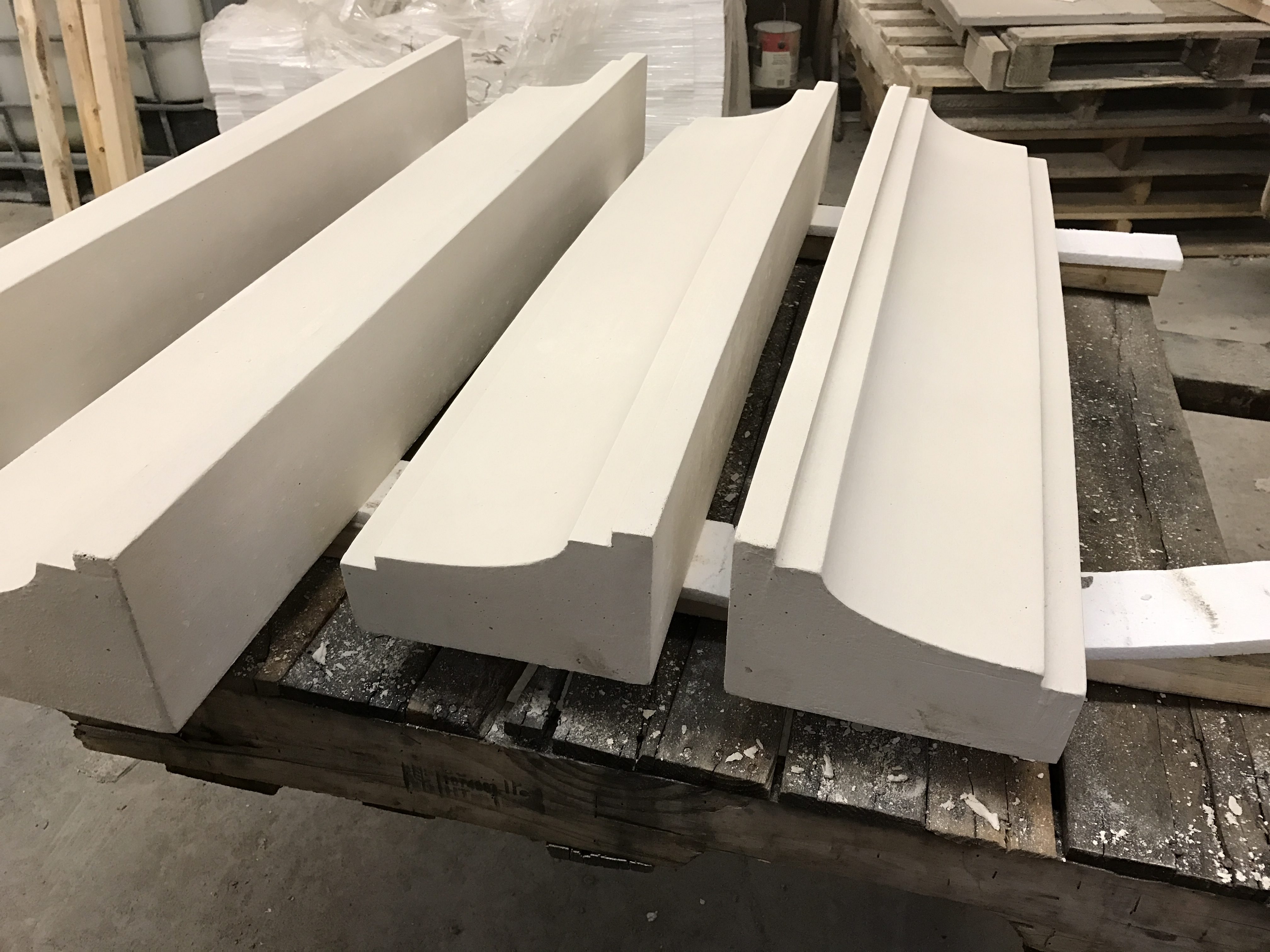 Custom cast stone profiles with cove detailing on a shop pallet